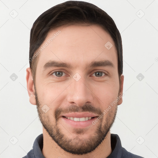 Joyful white young-adult male with short  brown hair and grey eyes