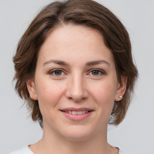 Joyful white young-adult female with medium  brown hair and grey eyes