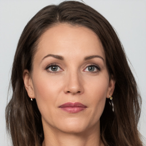 Joyful white adult female with long  brown hair and grey eyes