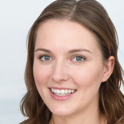 Joyful white young-adult female with long  brown hair and blue eyes