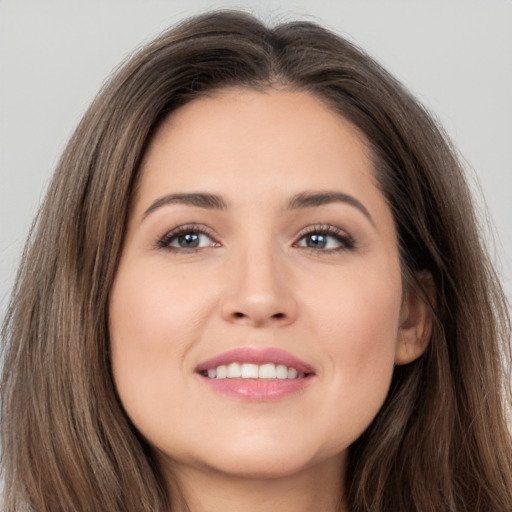 Joyful white young-adult female with long  brown hair and brown eyes