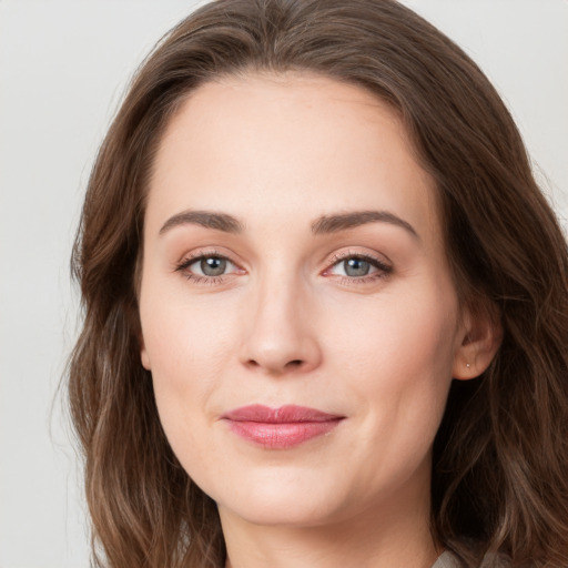 Joyful white young-adult female with long  brown hair and grey eyes