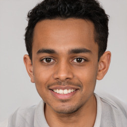 Joyful latino young-adult male with short  brown hair and brown eyes