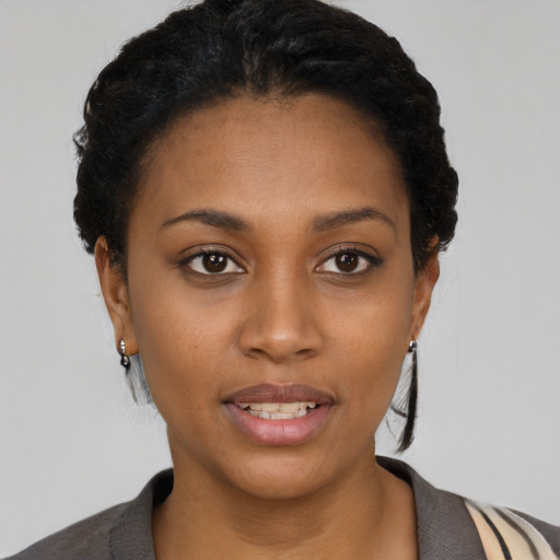 Joyful black young-adult female with short  black hair and brown eyes