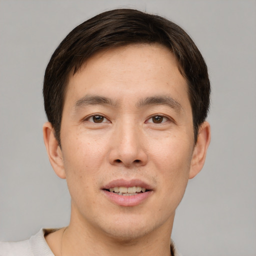 Joyful asian young-adult male with short  brown hair and brown eyes
