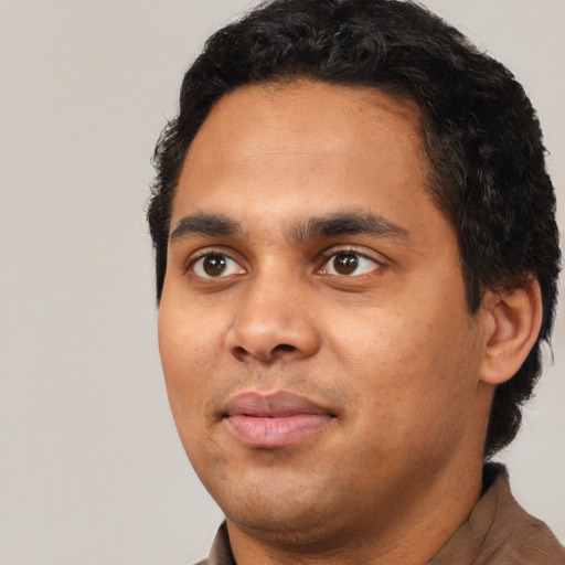 Joyful latino young-adult male with short  black hair and brown eyes