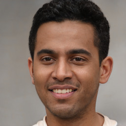 Joyful latino young-adult male with short  black hair and brown eyes