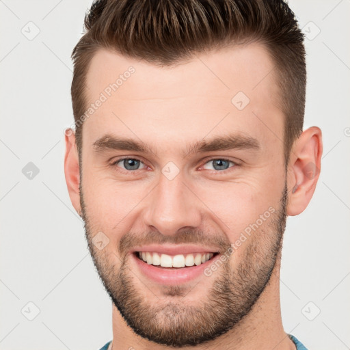 Joyful white young-adult male with short  brown hair and brown eyes