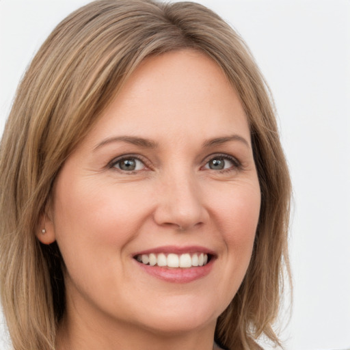 Joyful white young-adult female with long  brown hair and green eyes