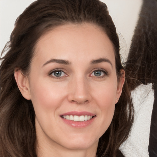 Joyful white young-adult female with long  brown hair and grey eyes