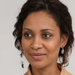 Joyful black adult female with medium  brown hair and brown eyes