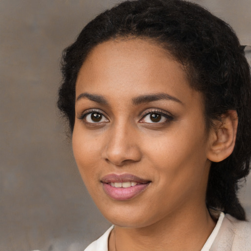Joyful black young-adult female with medium  brown hair and brown eyes