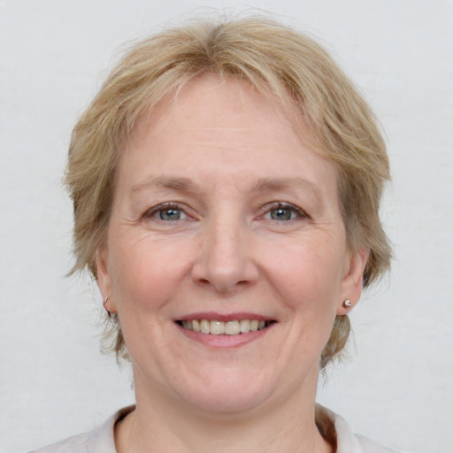 Joyful white adult female with medium  brown hair and blue eyes