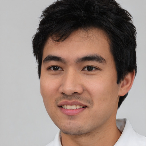 Joyful asian young-adult male with short  black hair and brown eyes