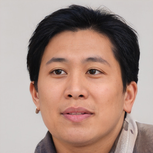 Joyful asian adult male with medium  brown hair and brown eyes