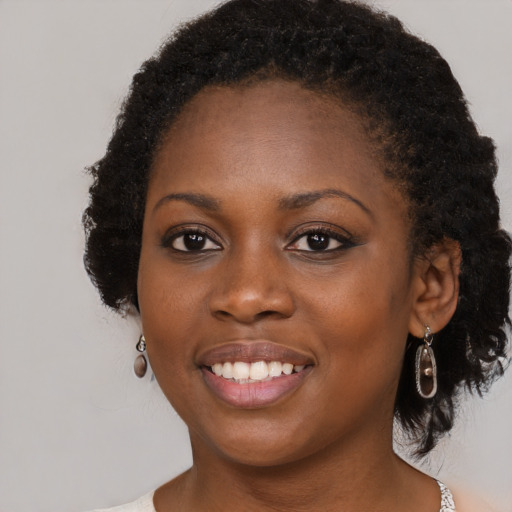 Joyful black young-adult female with medium  black hair and brown eyes