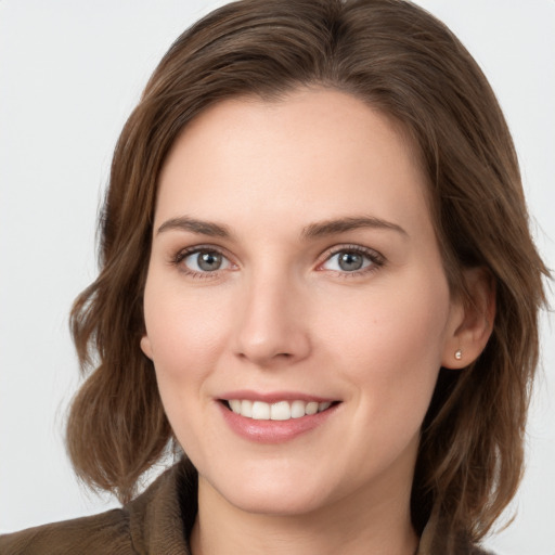 Joyful white young-adult female with medium  brown hair and grey eyes