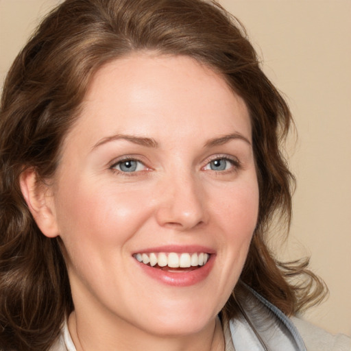 Joyful white young-adult female with medium  brown hair and blue eyes