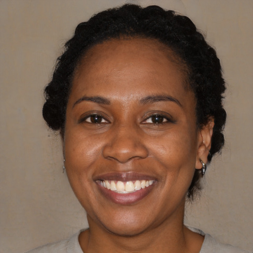 Joyful black adult female with short  brown hair and brown eyes