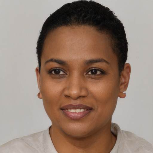 Joyful black young-adult female with short  black hair and brown eyes