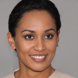 Joyful latino young-adult female with short  brown hair and brown eyes