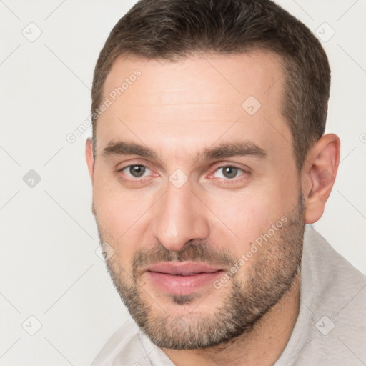 Joyful white young-adult male with short  brown hair and brown eyes