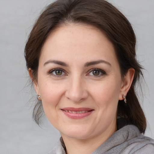 Joyful white adult female with medium  brown hair and brown eyes