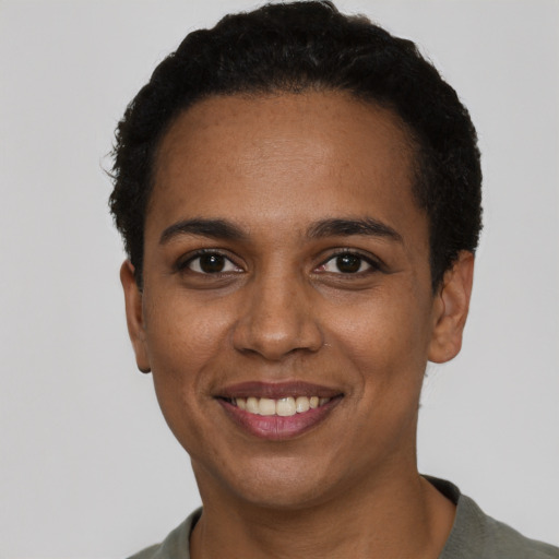 Joyful black young-adult female with short  black hair and brown eyes