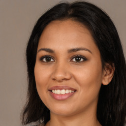 Joyful latino young-adult female with long  brown hair and brown eyes