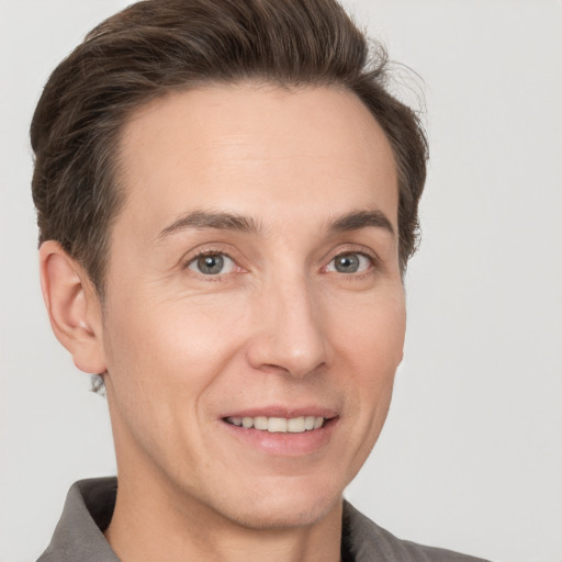 Joyful white adult male with short  brown hair and grey eyes