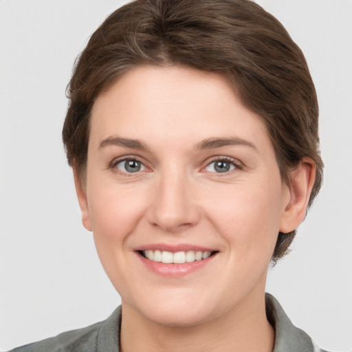 Joyful white young-adult female with short  brown hair and grey eyes