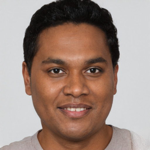 Joyful black young-adult male with short  black hair and brown eyes
