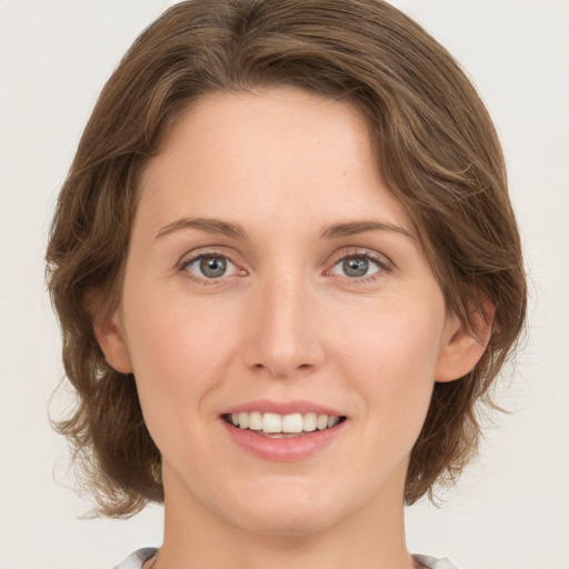 Joyful white young-adult female with medium  brown hair and green eyes