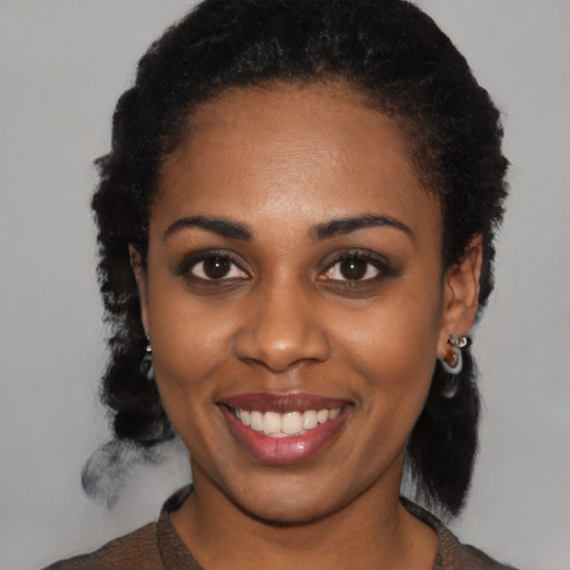 Joyful black young-adult female with medium  black hair and brown eyes