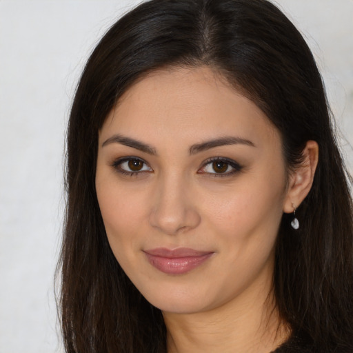 Joyful latino young-adult female with long  brown hair and brown eyes