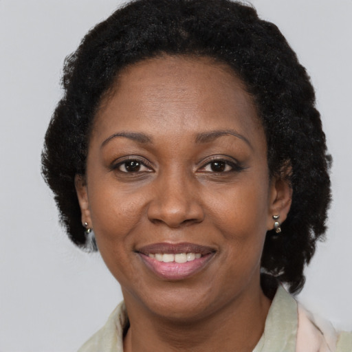 Joyful black adult female with short  brown hair and brown eyes