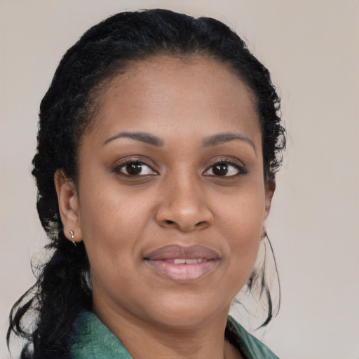 Joyful black young-adult female with long  brown hair and brown eyes