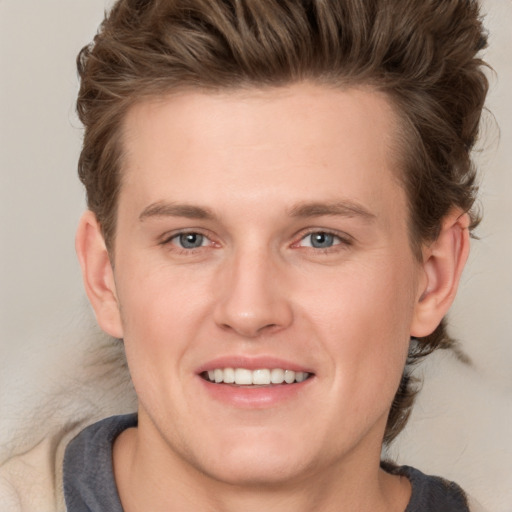 Joyful white young-adult male with medium  brown hair and grey eyes