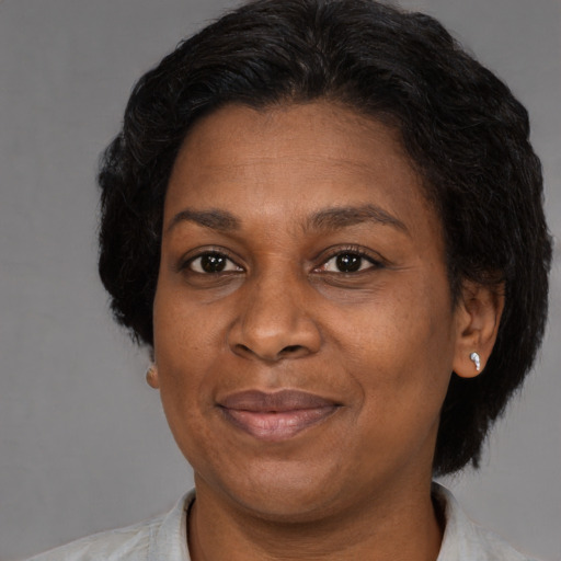 Joyful black adult female with short  brown hair and brown eyes