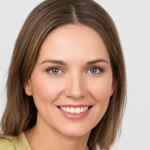 Joyful white young-adult female with medium  brown hair and green eyes