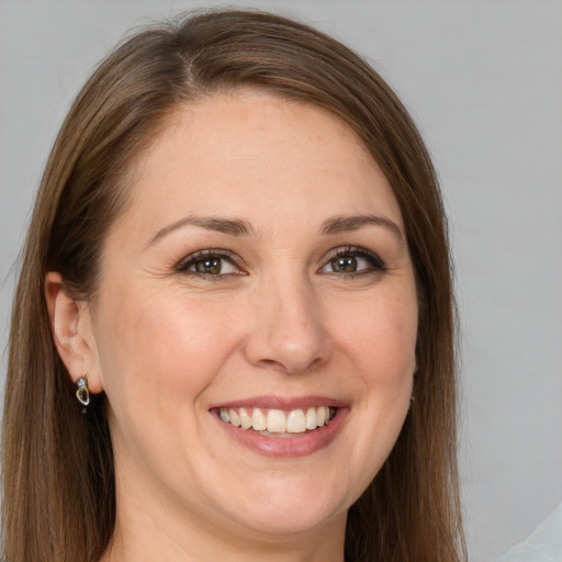 Joyful white adult female with long  brown hair and grey eyes