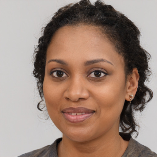 Joyful black young-adult female with medium  brown hair and brown eyes