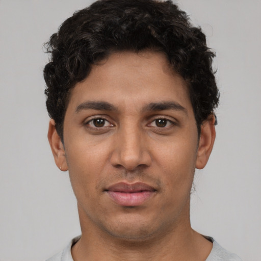 Joyful latino young-adult male with short  brown hair and brown eyes