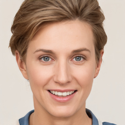 Joyful white young-adult female with short  brown hair and grey eyes