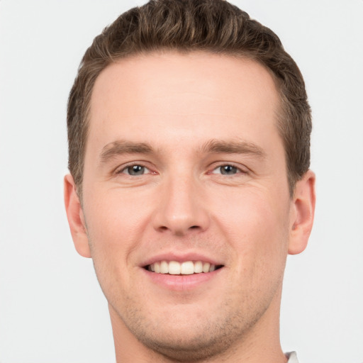 Joyful white young-adult male with short  brown hair and grey eyes