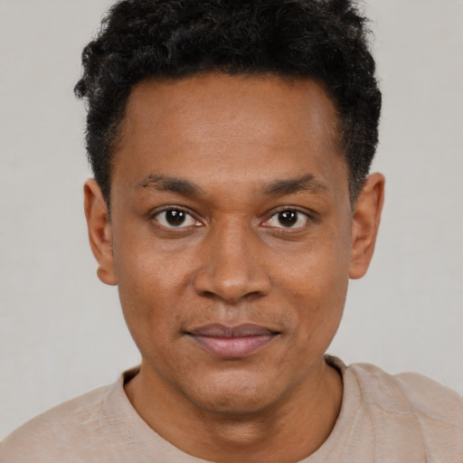 Joyful black young-adult male with short  brown hair and brown eyes