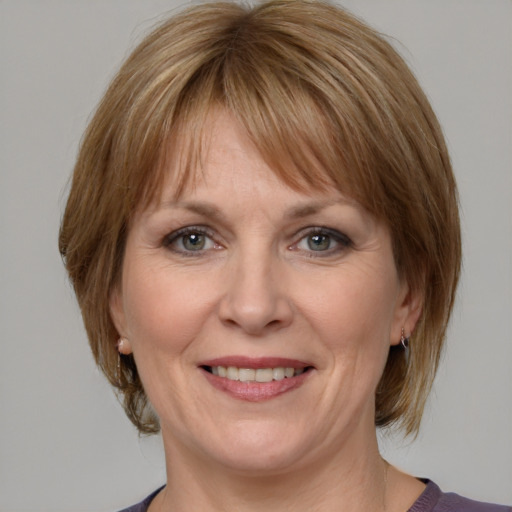 Joyful white adult female with medium  brown hair and grey eyes