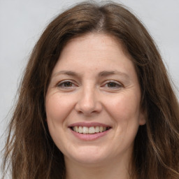 Joyful white adult female with long  brown hair and brown eyes