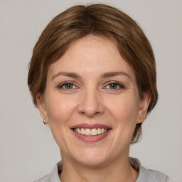 Joyful white adult female with medium  brown hair and grey eyes