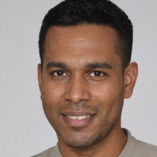 Joyful black young-adult male with short  black hair and brown eyes